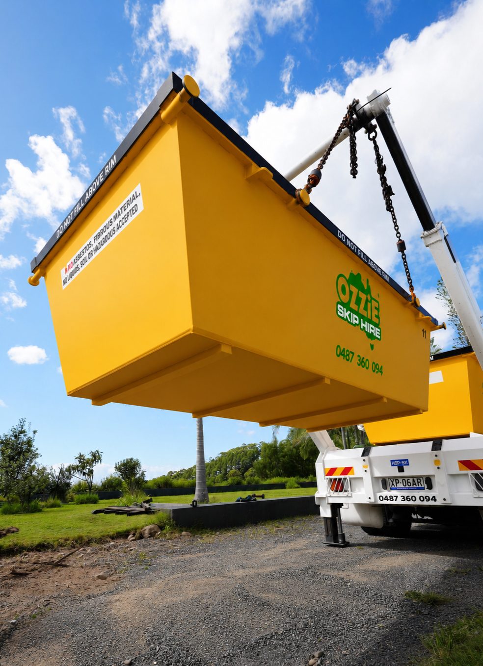Skip bin lifted onto an Ozzie Skip Hire truck by the loading arms